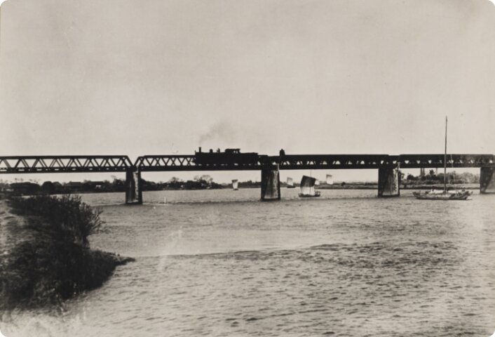 常磐線鉄橋を渡る蒸気機関車と江戸川の帆船